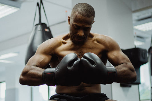 Boxer wearing black boxing gloves in a bright gym
