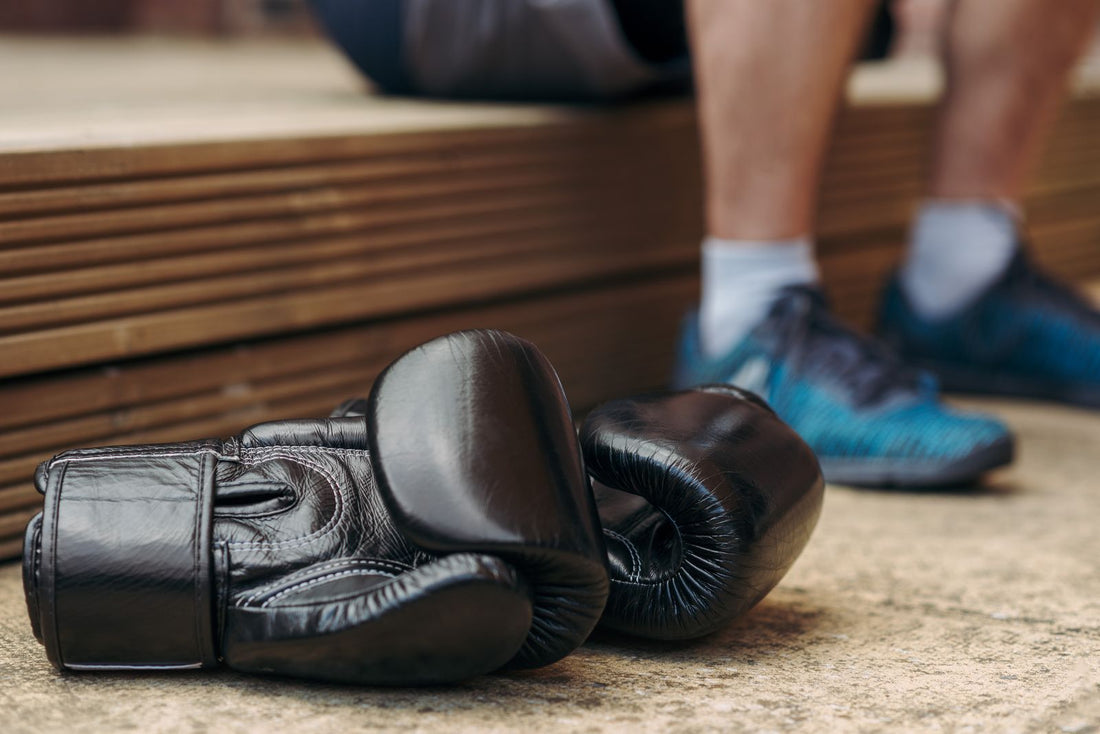 Pair of black boxing gloves on the gym floor after training