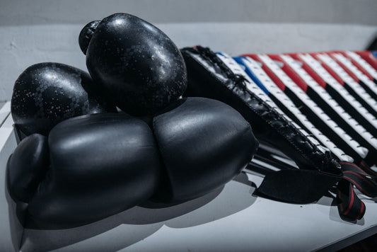 Boxing gloves, hand wraps and shorts laid out on a bench