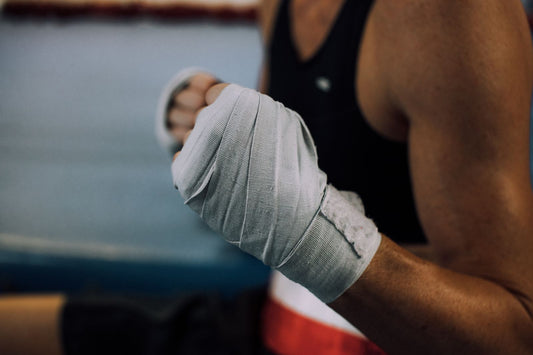 Close up of a boxer's hand wrapped in worn grey hand wraps