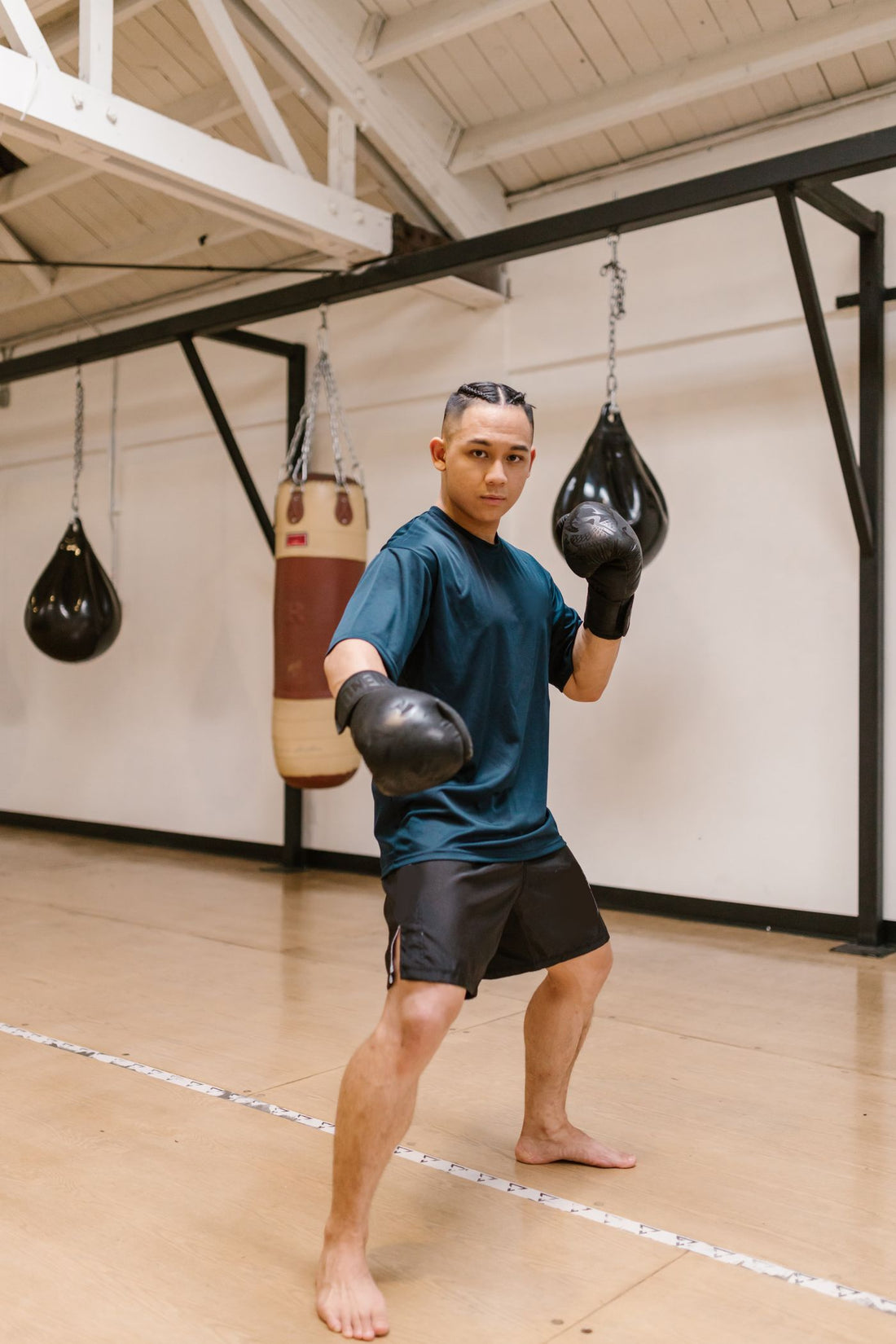Boxer in a bright gym wearing black training gloves