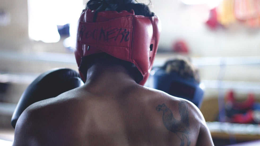 Boxer from behind wearing red headgear in a boxing ring