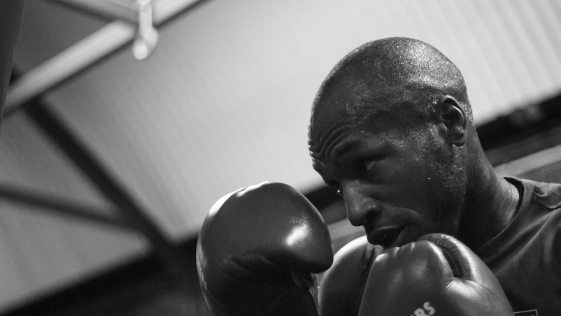 Black and white close-up of a boxer in guard position with gloves raised