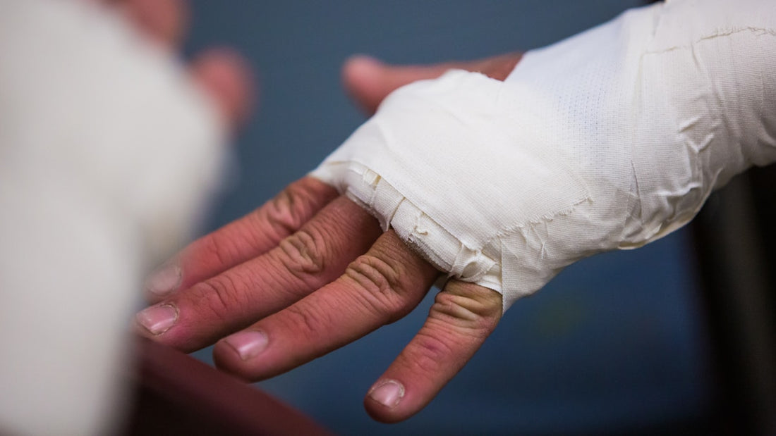Close-up of a hand wrapped in white tape with fingers visible