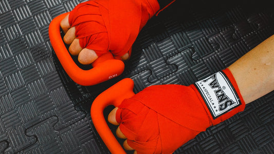 Hands wrapped in red boxing hand wraps ready for training