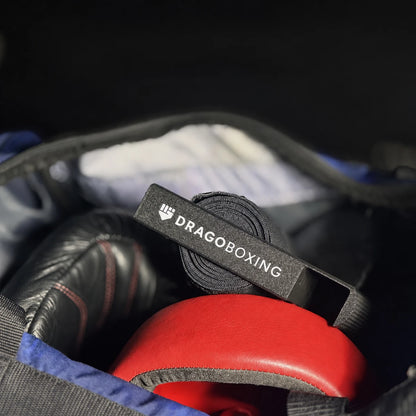 Drago Roller packed in a gym bag on top of rolled hand wraps, gloves and headgear